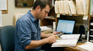 Buyer-side financial analyst examining a veterinary practice's records and financial statements during due diligence