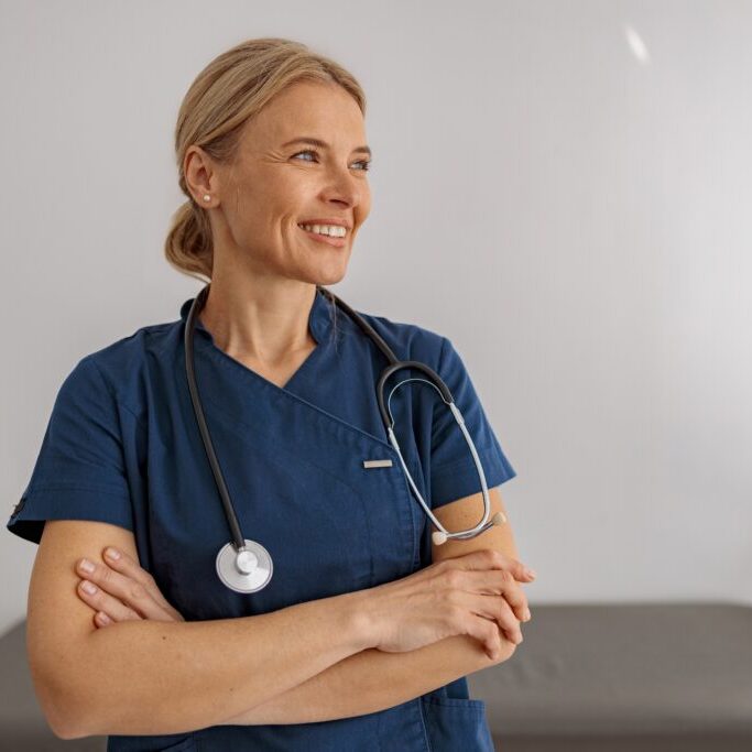 Smiling,Professional,Woman,Doctor,With,Stethoscope,On,Her,Workplace,In